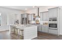 Modern kitchen with stainless steel appliances, island with breakfast bar, and gray cabinetry at 136 Maritime Way, Summerville, SC 29485
