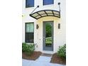 A stylish front entrance highlighting a gray door with awning, modern lighting, and manicured landscaping, creating curb appeal at 1510 Cecile St, Mount Pleasant, SC 29464
