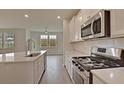 Modern kitchen with stainless steel appliances, island with sink, and lots of natural light through large windows at 197 Belfort Pl, Summerville, SC 29486