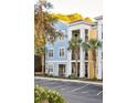 Exterior view of a three-story building featuring colorful accents, palm trees, and a well-maintained parking area at 2200 Belle Isle Ave # 103, Mount Pleasant, SC 29464