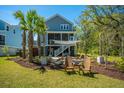 Landscaped backyard featuring a fire pit and covered porch at 2322 Dorado Ct, Johns Island, SC 29455