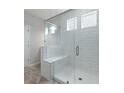 Modern bathroom shower with glass doors, white tile and built-in bench at 234 Silk Oak Dr, Moncks Corner, SC 29461