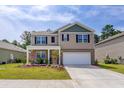 Inviting two-story home featuring blue shutters, a two-car garage, and a well-maintained lawn at 243 N Light Way, Summerville, SC 29486