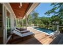 Relaxing backyard pool with wooden deck, lounge chairs, and a covered outdoor space at 2501 Clear Marsh Rd, Seabrook Island, SC 29455