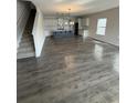 Open-concept living room leading to kitchen with hardwood floors and staircase to the upper level at 280 Godwit Dr, Summerville, SC 29486
