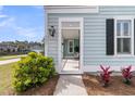 Inviting front entrance with light blue siding and black shutters, framed by lush greenery at 2837 Rutherford Way, Charleston, SC 29414
