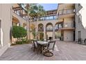 Inviting courtyard area with stone pavers, seating, palm trees and multi-story condo views at 3005 Ocean Winds Dr, Seabrook Island, SC 29455