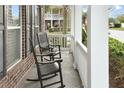 Relaxing front porch features slate flooring, rocking chairs, and white railings at 3025 Lazarette Ln, Charleston, SC 29414