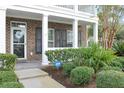 Inviting front porch with brick columns, black shutters, and meticulously maintained landscaping at 3025 Lazarette Ln, Charleston, SC 29414