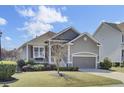 Charming single-Gathering home with inviting covered entry, attached garage, and well-manicured front lawn at 345 Turnstone St, Mount Pleasant, SC 29464