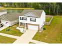 Aerial of home featuring white siding and brick accents, set on a landscaped lot near a pond and surrounded by trees at 436 Cedarview Rd, Summerville, SC 29486