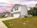 Well-maintained home featuring white siding, a brick-accented front, a two-car garage, and a lush, green lawn at 436 Cedarview Rd, Summerville, SC 29486