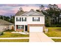 Charming two-story home with classic white siding, brick accents, a two-car garage, and a meticulously landscaped front yard at 436 Cedarview Rd, Summerville, SC 29486