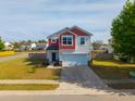 Two-story home with neutral siding and a red trimmed gable, front yard and attached garage in a bright setting at 4818 Pitkin Ave, Ladson, SC 29456