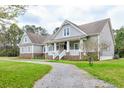 Beautiful two-story home with stone accents, a gravel driveway, and a welcoming front porch at 4846 Causey Pond Rd, Awendaw, SC 29429
