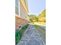 A stone walkway runs along the side of this home with stone accents and a manicured lawn at 4846 Causey Pond Rd, Awendaw, SC 29429
