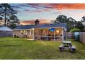 Spacious backyard featuring a screened-in porch with a TV and outdoor furniture at 4984 Foxwood Dr, North Charleston, SC 29418