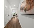 Inviting hallway with hardwood floors and modern art leading into a brightly lit living space at 739 Meadowbrook Ln, Summerville, SC 29486