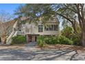 Beautiful raised home with covered parking, mature trees, and well-kept landscaping at 740 Spinnaker Beachhouses, Seabrook Island, SC 29455