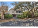 Inviting raised home with covered parking, mature trees, and a well-manicured yard at 740 Spinnaker Beachhouses, Seabrook Island, SC 29455