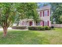 Inviting two-story home with a covered front porch, manicured lawn, and a vibrant American flag at 9360 S Moreto Cir, Summerville, SC 29485