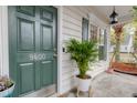 Attractive front door displaying house number with sidelight window, potted plants and lantern-style porch light at 9400 Divot Ln, Summerville, SC 29485