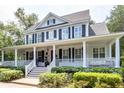 Charming two-story home boasting a welcoming porch, black shutters, and lush landscaping at 1021 Barfield St, Charleston, SC 29492