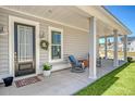 Cozy front porch featuring a classic rocking chair, a charming wreath, and a welcoming entrance at 106 Wood Sage Run, Summerville, SC 29485