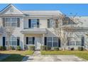 Inviting townhome exterior showcasing neat landscaping, a front porch, and classic architectural details at 128 Black River Dr, Summerville, SC 29485