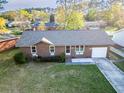 Well-manicured lawn with charming brick home featuring attached garage in established neighborhood at 132 Heather Dr, Summerville, SC 29486