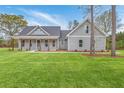 Attractive gray home with a covered front porch and lush green lawn on a bright day at 136 Mitch Ln, Holly Hill, SC 29059