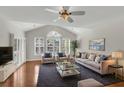 Bright living room features vaulted ceilings, shuttered windows, hardwood floors, and stylish decor at 1362 Kingsford Ln, Mount Pleasant, SC 29466