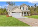 Well-maintained two-story home with a spacious lawn, two-car garage, and a long driveway at 153 Mitch Ln, Holly Hill, SC 29059
