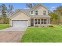Well-maintained two-story home with a spacious lawn, two-car garage, and a driveway at 153 Mitch Ln, Holly Hill, SC 29059