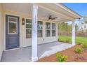 Inviting front porch featuring a ceiling fan, craftsman-style columns, and a view of the front yard at 153 Mitch Ln, Holly Hill, SC 29059