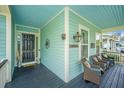 Charming porch with ample seating, decorative elements, and classic lantern, seamlessly blending style with comfort at 1543 Watoga Way, Mount Pleasant, SC 29466
