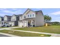 Inviting two-story home boasting a well-maintained lawn, attached garage, and a charming front porch area at 157 Tuscan Sun St, Summerville, SC 29485