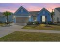 Charming single-story home with a well-maintained lawn, two-car garage, and inviting curb appeal at dusk at 159 Garden Gate Way, Summerville, SC 29486
