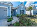 Inviting front entrance with a charming door, decorative wreath, and lush landscaping with colorful flowers at 159 Garden Gate Way, Summerville, SC 29486