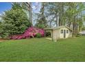 Spacious backyard featuring a quaint shed surrounded by lush greenery and colorful azaleas at 1636 Pinopolis Rd, Moncks Corner, SC 29461