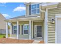 View of the front porch, showing hanging plants, and the address number next to the exterior light at 189 Weeping Cypress Dr, Moncks Corner, SC 29461
