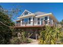 Inviting coastal home featuring a spacious deck and lush greenery for privacy at 1908 Palmetto Boulevard Blvd, Edisto Island, SC 29438