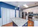 Updated kitchen featuring stainless steel appliances, a blue island with a granite countertop, and ample cabinet space at 218 Candleberry Cir, Goose Creek, SC 29445