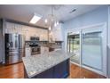 Open-concept kitchen with stainless steel appliances, white cabinetry, granite countertops, and a view of the backyard at 218 Candleberry Cir, Goose Creek, SC 29445