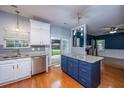 Bright kitchen with white cabinets, granite countertops, stainless steel appliances, and a blue center island with hardwood flooring at 218 Candleberry Cir, Goose Creek, SC 29445