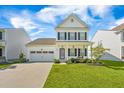 Inviting two-story home showcasing a manicured lawn, two-car garage, and a welcoming front porch at 260 Dunlin Dr, Summerville, SC 29486