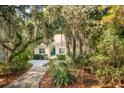 Inviting home exterior showcasing mature trees, manicured landscaping, and a quaint walkway to the front door at 2737 Old Forest Dr, Seabrook Island, SC 29455