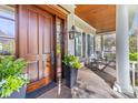 Elegant entryway features a rich wood door, covered porch, and stylish decor at 278 Furman Farm Pl, Daniel Island, SC 29492