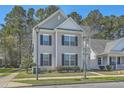 Classic two-story home featuring blue shutters, green lawn and a welcoming front porch at 3073 Moonlight Dr, Charleston, SC 29414