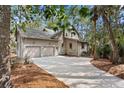Home exterior featuring a two-car garage, neutral siding, and a paved driveway at 3180 Pine Needle Ln, Seabrook Island, SC 29455